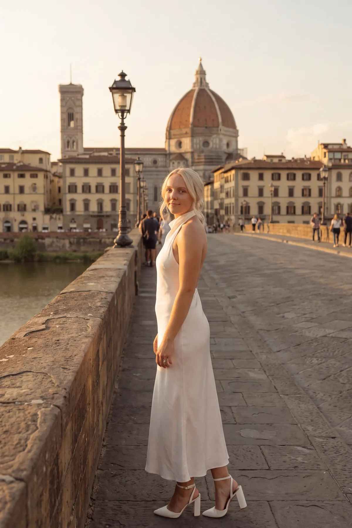 Reagan on a stone bridge in Florence with the Duomo behind her at sunset